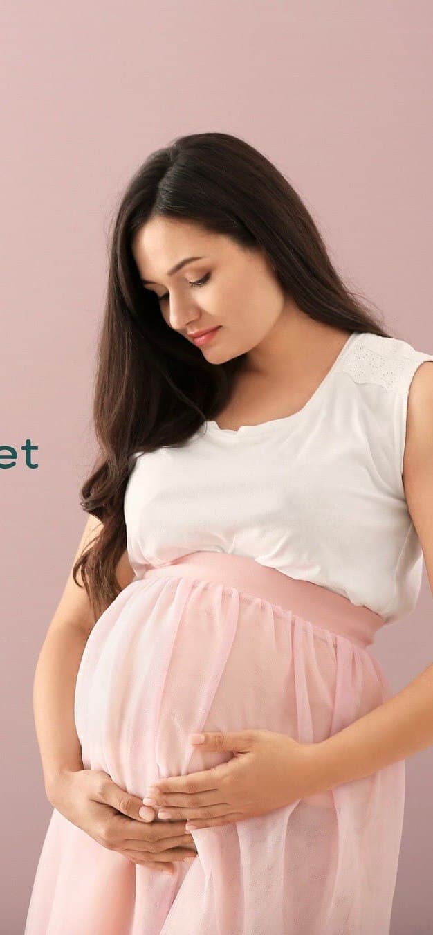 An expectant surrogate cradling her bump